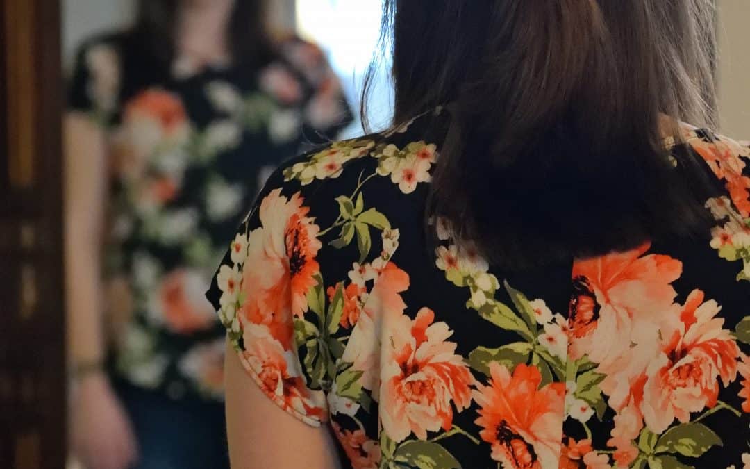 woman standing in front of mirror in floral top